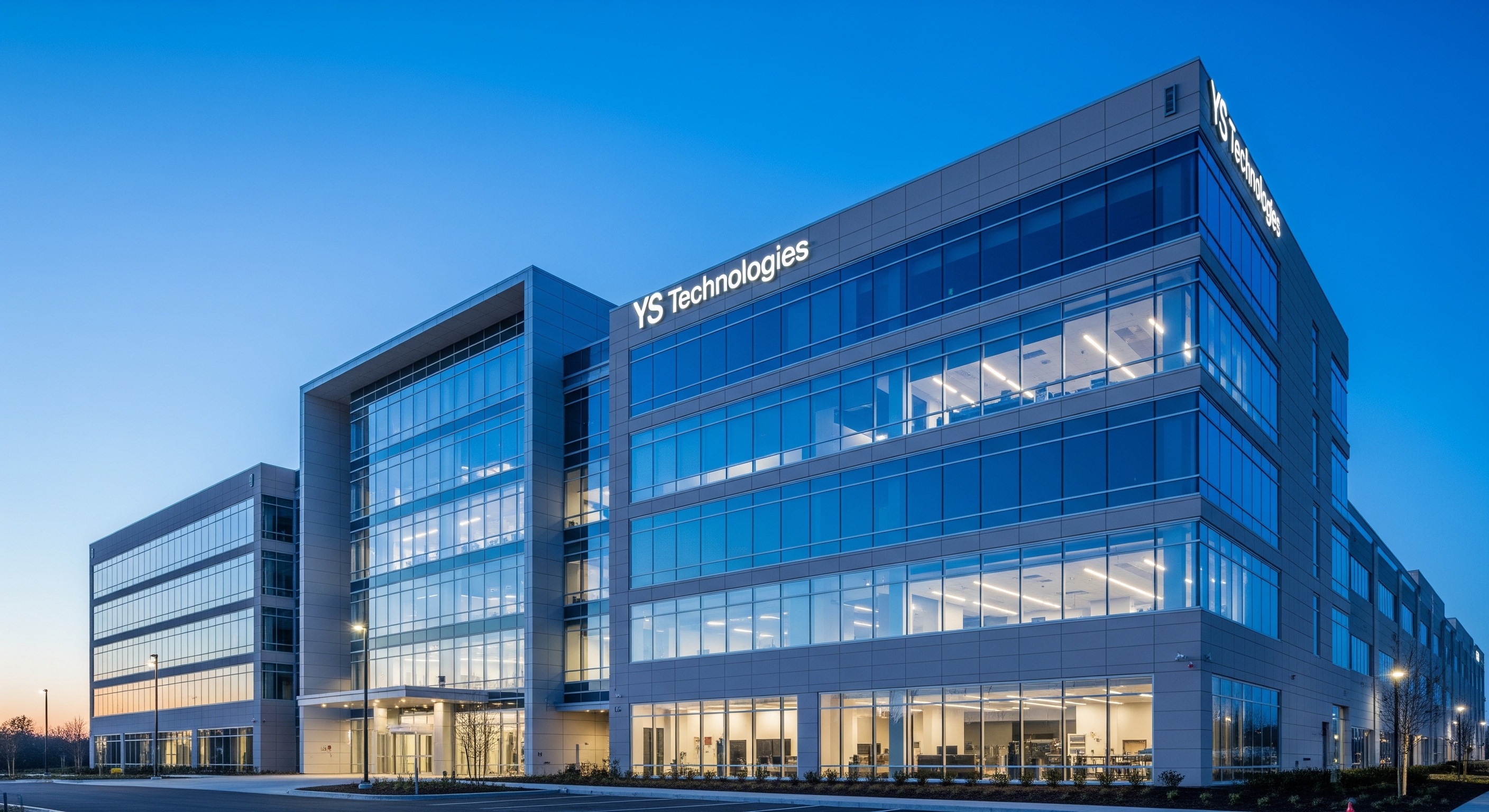 Modern YS Technologies corporate building exterior at dusk with professional architecture and glass facade